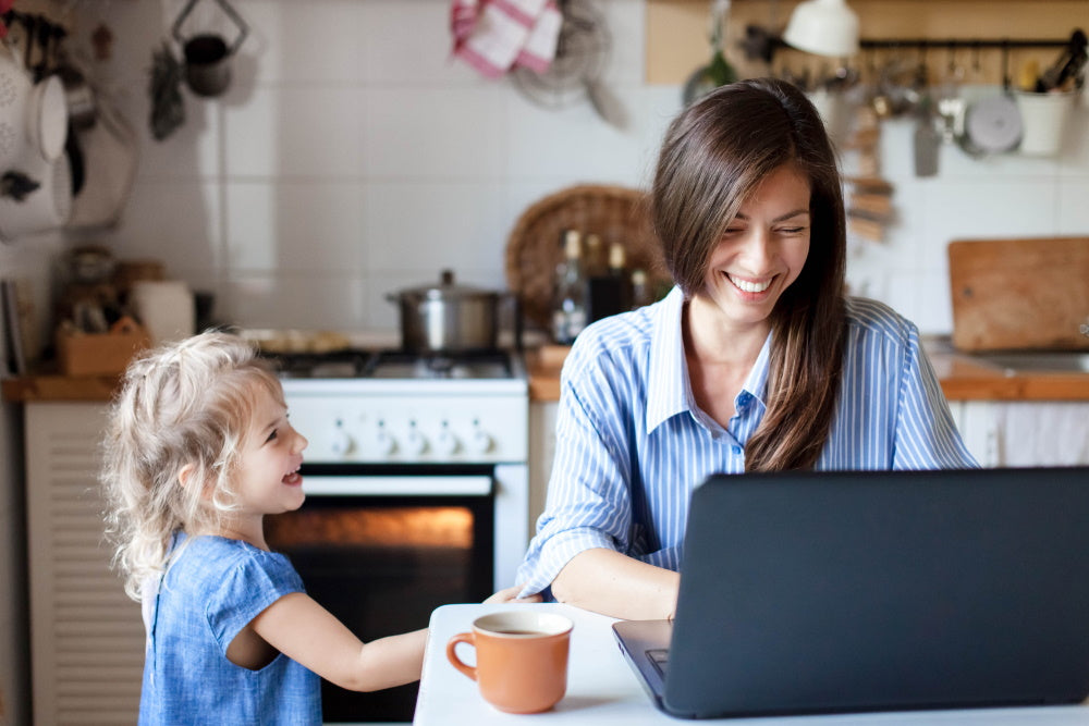 mother and daughter in kitchen using laptop